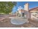 Backyard view features a concrete patio, gravel landscaping, and partial home exterior with chimney at 9421 Gold Mountain Dr, Las Vegas, NV 89134