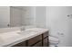 Modern bathroom vanity with a sink and wood-look cabinetry, complemented by a toilet and mirror at 965 Nevada State Dr # 39201, Henderson, NV 89002