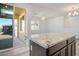 Kitchen island featuring granite countertops adjacent to the balcony with natural light at 965 Nevada State Dr # 39201, Henderson, NV 89002