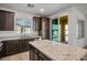 Kitchen with granite countertops, dark cabinets, and stainless steel appliances adjacent to the balcony at 965 Nevada State Dr # 39201, Henderson, NV 89002