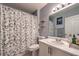 Well-maintained bathroom with a shower, patterned curtain, vanity, and a bright mirror, providing a functional space at 9655 Idle Spurs Dr, Las Vegas, NV 89123