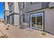 View of the home's exterior showing the gravel yard, windows, and sliding glass door leading to the backyard at 10148 Mulberry Ridge St # 38, Las Vegas, NV 89141