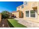 Inviting backyard with a small patio, artificial grass, and lush landscaping offering a private outdoor space at 1016 Douglas Flat Pl, Las Vegas, NV 89138