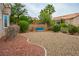 Landscaped backyard featuring desert landscaping, shrubs, trees, and a rock garden at 10320 Bent Brook Pl, Las Vegas, NV 89134