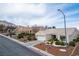 Scenic view of a single-story home with desert landscaping, two-car garage, and peaceful surroundings at 10320 Bent Brook Pl, Las Vegas, NV 89134