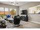 Bright living room features wood floors, a ceiling fan, and a view into the kitchen at 10320 Bent Brook Pl, Las Vegas, NV 89134