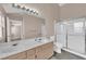 Bright bathroom featuring a double sink vanity, tiled floors, and a walk-in shower at 104 Hutton Ln, Las Vegas, NV 89145