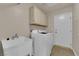 Functional laundry room with white washer and dryer, sink, and storage cabinets at 104 Hutton Ln, Las Vegas, NV 89145