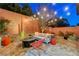 Cozy backyard with desert plants, seating area, firepit, and ambient string lights at 10564 Tranquil Glade Ln, Las Vegas, NV 89135