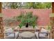 Backyard featuring an outdoor water feature, cacti, stone bench, and chairs on a paved patio at 10564 Tranquil Glade Ln, Las Vegas, NV 89135