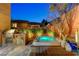 Backyard with a built-in spa, outdoor kitchen, and privacy wall with lush greenery at 10564 Tranquil Glade Ln, Las Vegas, NV 89135