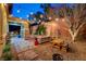 Charming backyard with gravel, brick, ambient string lights, and cozy seating area at 10564 Tranquil Glade Ln, Las Vegas, NV 89135