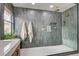 Modern bathroom features a spacious glass shower with gray tiling and double shower heads at 10564 Tranquil Glade Ln, Las Vegas, NV 89135