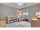 Bedroom with a crib, chair, and neutral color scheme at 10564 Tranquil Glade Ln, Las Vegas, NV 89135