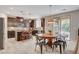 Open-concept kitchen featuring stainless steel appliances, a breakfast bar, and a dining area at 10564 Tranquil Glade Ln, Las Vegas, NV 89135