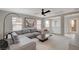 Inviting living room with large sectional, contemporary decor, and ample natural light, adjacent to the stairway at 10564 Tranquil Glade Ln, Las Vegas, NV 89135