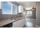 Bright kitchen featuring white cabinets, stone countertops, stainless steel sink and wood floors at 1844 N Decatur Blvd # 203, Las Vegas, NV 89108