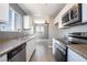 Kitchen featuring white cabinets, stone countertops, stainless steel appliances and wood floors at 1844 N Decatur Blvd # 203, Las Vegas, NV 89108