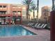 Community swimming pool with lounge chairs and palm trees at 19 E Agate Ave # 406, Las Vegas, NV 89123