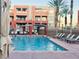 Inviting community pool area with lounge chairs, palm trees, and a covered seating area for residents to enjoy at 19 E Agate Ave # 406, Las Vegas, NV 89123