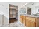 Bright bathroom with a granite-topped vanity, dual sinks, and walk-in closet access, complemented by marble flooring at 1911 Hobson Dr, Henderson, NV 89074