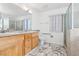 Bathroom featuring dual sinks, granite countertops, a large mirror, a walk-in shower, and elegant marble tile flooring at 1911 Hobson Dr, Henderson, NV 89074