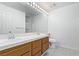 Bathroom featuring double sinks, wooden cabinets, and a large mirror with vanity lighting at 1911 Hobson Dr, Henderson, NV 89074