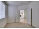 Bright bedroom with a view into the living room with neutral paint, window, and light colored carpet at 205 Crown Imperial St, Henderson, NV 89074