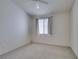 Bedroom featuring a window with decorative curtains, ceiling fan, and neutral colored carpet at 205 Crown Imperial St, Henderson, NV 89074