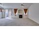 Spacious living room with fireplace, carpet flooring, and sliding glass door to the patio at 205 Crown Imperial St, Henderson, NV 89074