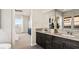 Sleek bathroom with double vanity, dark cabinets, and modern fixtures, adjacent to a bedroom with scenic views at 22 Barrio Alto Ct, Henderson, NV 89011