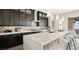 Modern kitchen featuring dark cabinets, a white countertop island with seating, and stainless steel appliances at 22 Barrio Alto Ct, Henderson, NV 89011