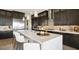 Kitchen featuring a center island with seating, dark cabinetry, and stainless steel appliances at 22 Barrio Alto Ct, Henderson, NV 89011