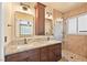 Well lit bathroom with a double granite vanity, and a glass shower with tile and pebble flooring at 2213 Midvale Ter, Henderson, NV 89074