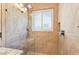 Modern tile shower with glass enclosure, shower head, window, seat, and built in shelving at 2213 Midvale Ter, Henderson, NV 89074