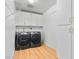 This laundry room features gray front load machines with white cabinets and wood-look floors at 2620 San Martin Ct, Las Vegas, NV 89121