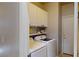 Efficient laundry area with modern washer and dryer, ample cabinetry, and neat shelving for storage at 2713 Tanagrine Dr, North Las Vegas, NV 89084