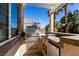 A built-in outdoor kitchen with stainless steel grill and tile countertop under covered patio at 2713 Tanagrine Dr, North Las Vegas, NV 89084