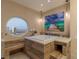 Modern bathroom with a relaxing soaking tub, custom wood paneling, and a round window showcasing beautiful cityscape views at 2747 Paradise Rd # Ph 3604, Las Vegas, NV 89109