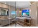 Modern bathroom showcasing a luxurious soaking tub, walk-in shower, and expansive round window with breathtaking scenic views at 2747 Paradise Rd # Ph 3604, Las Vegas, NV 89109