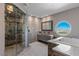 Bright bathroom featuring a glass-enclosed shower, sleek vanity, and a unique round window framing picturesque city views at 2747 Paradise Rd # Ph 3604, Las Vegas, NV 89109