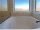 Close-up of a relaxing bathtub with jets beneath a bright window at 2756 Blairgowrie Dr, Henderson, NV 89044