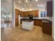 Open-concept kitchen featuring wooden cabinets, an island, and tile flooring at 2756 Blairgowrie Dr, Henderson, NV 89044