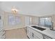 Open-concept kitchen island with sink, white cabinetry, and a view to the patio at 3061 Key Largo Dr # 201, Las Vegas, NV 89120