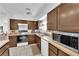 Kitchen features dark wood cabinets, tile countertops, and standard appliances at 4301 Fortune Ave, Las Vegas, NV 89107