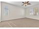 Bedroom with neutral carpet, ceiling fan, and large windows allowing natural light at 5323 Farley Feather Ct, North Las Vegas, NV 89031