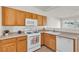 Kitchen features wooden cabinets, white appliances, and a view into the adjacent living area at 5323 Farley Feather Ct, North Las Vegas, NV 89031