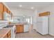 Bright kitchen with wooden cabinets, white appliances, and a view of the living room at 5323 Farley Feather Ct, North Las Vegas, NV 89031