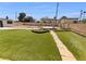 Landscaped backyard with pergola, green grass, and low-maintenance desert landscaping at 5413 Avenida Caballo, Las Vegas, NV 89108