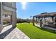 Backyard showcases a large pergola and artificial turf, creating a wonderful outdoor living space at 59 Strada Loreto, Henderson, NV 89011